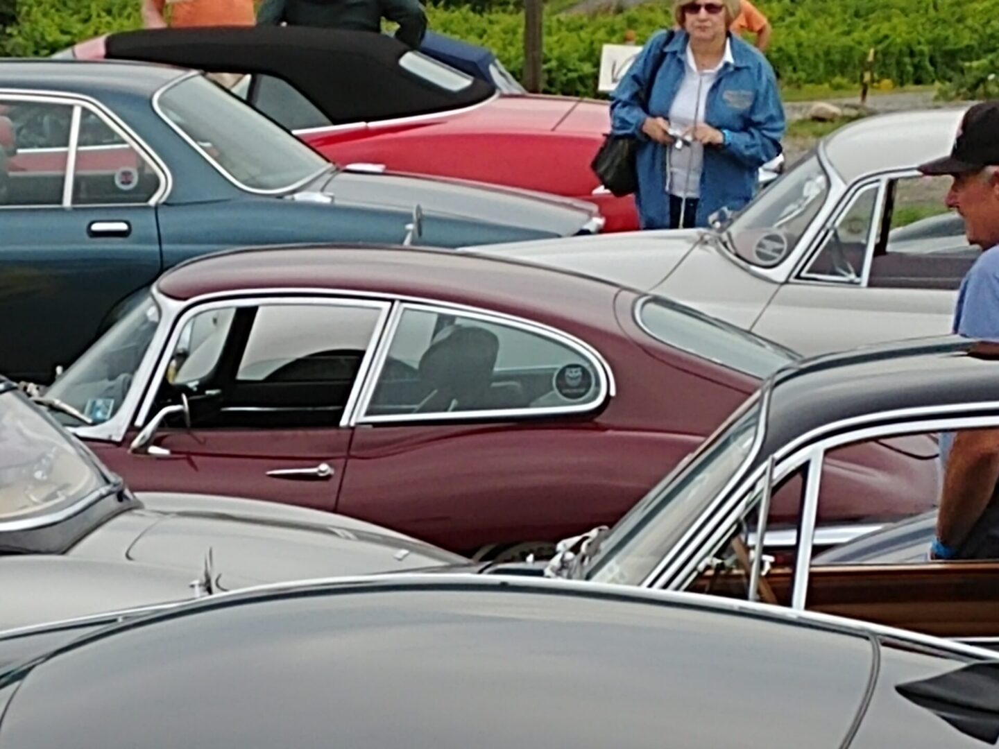 A woman standing in front of many parked cars.