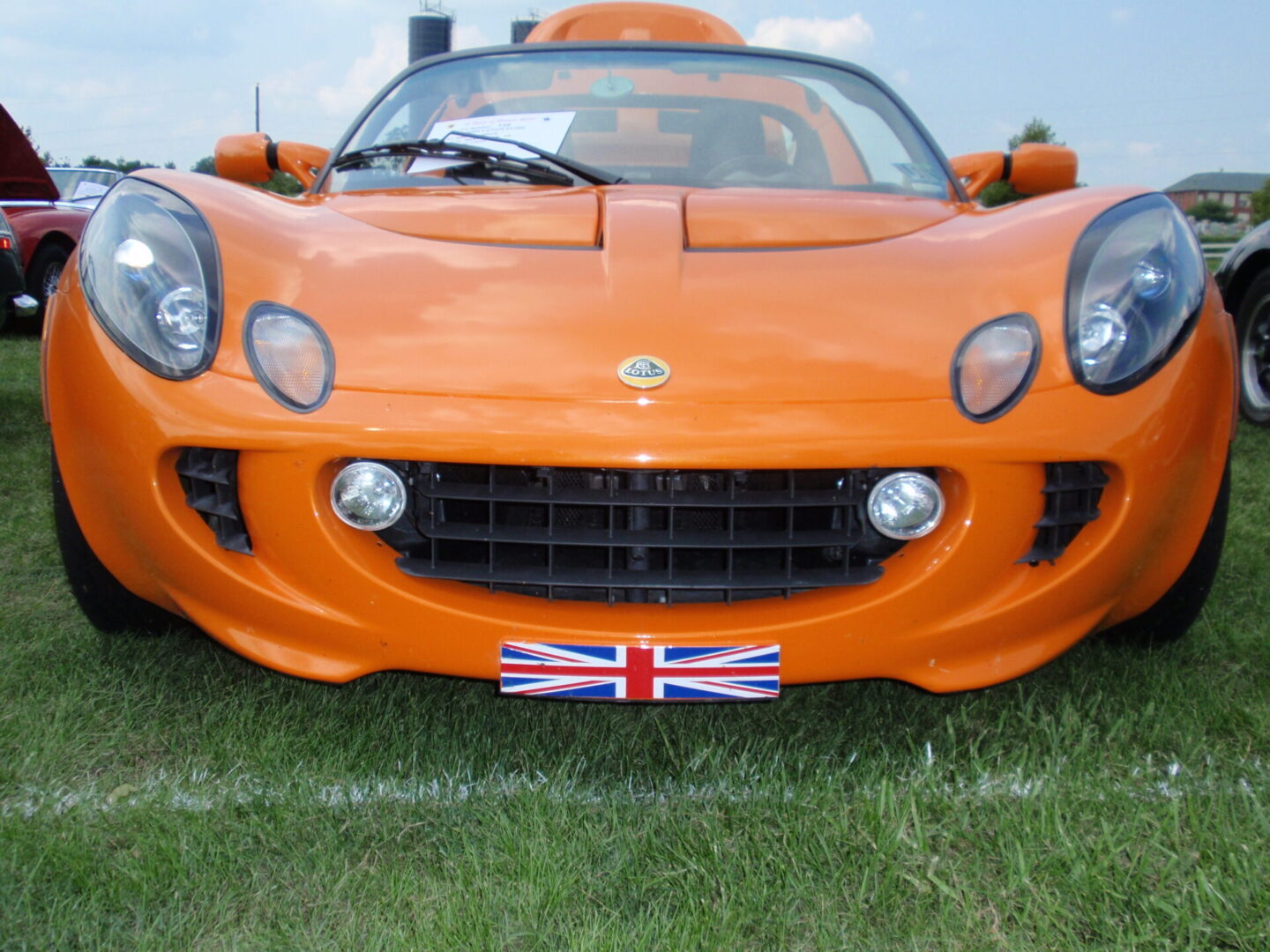 A close up of an orange sports car with the british flag on it.