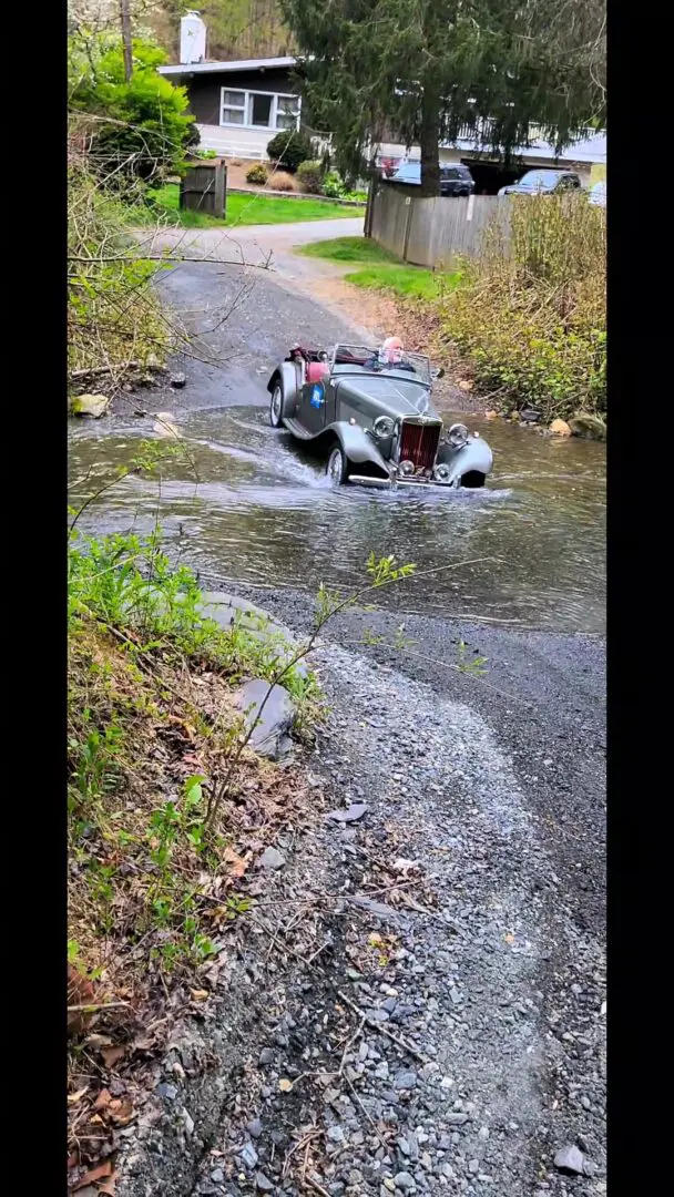 A car that is in the water on the road.