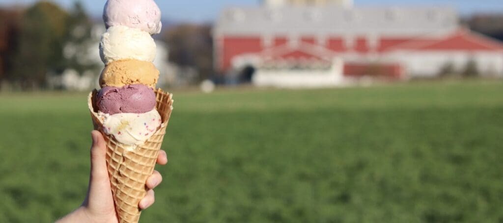 Hand holding a four-scoop ice cream cone.